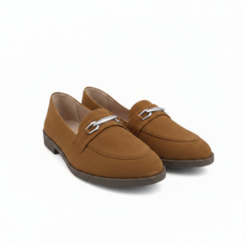 A pair of tan suede penny loafers with silver-tone metal horsebit details on the vamp, displayed on a white studio floor.