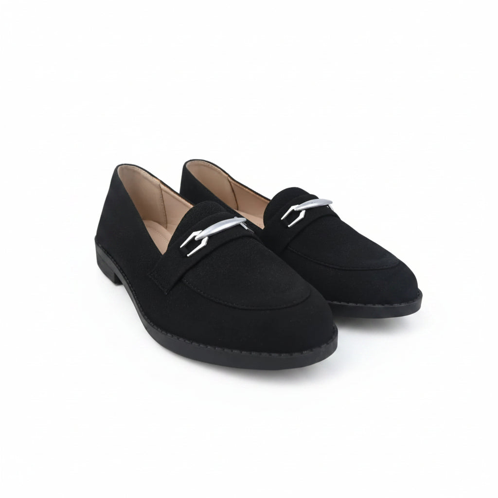 A pair of tan suede penny loafers with silver-tone metal horsebit details on the vamp, displayed on a white studio floor.