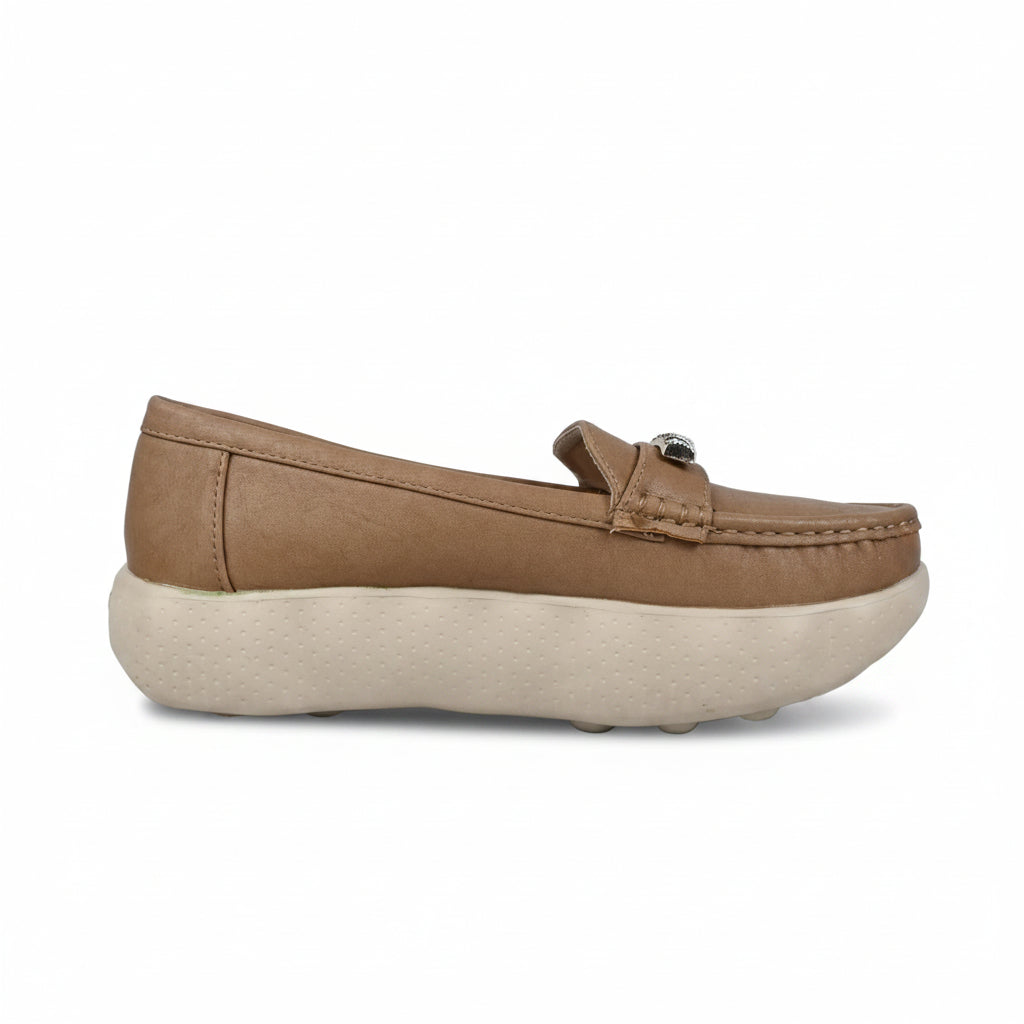 A single tan slip-on loafer-style shoe with a thick cream-colored sole, photographed from the side against a light gray backdrop.