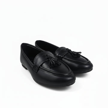 A pair of black leather tassel loafers photographed on a white studio background.