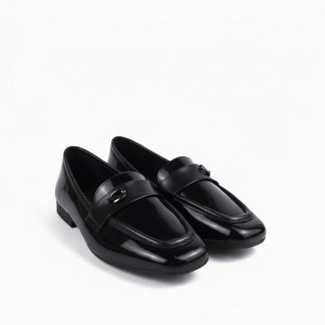 A pair of glossy black patent leather loafers with a small silver-tone horsebit detail on the strap, displayed on a white studio background.