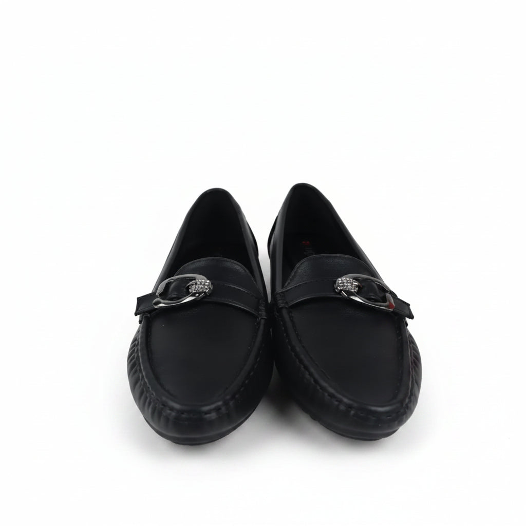 A pair of black leather loafers with a silver-tone metal horsebit detail across the vamp, displayed on a white surface with a red and black shoebox partially visible on the right.