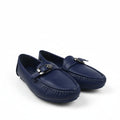 A pair of navy blue leather penny loafers with silver-tone buckle details, displayed on a light gray fabric backdrop.