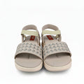 A pair of woven beige sandals with pale yellow straps, shown next to a red Mettler box on a white surface.