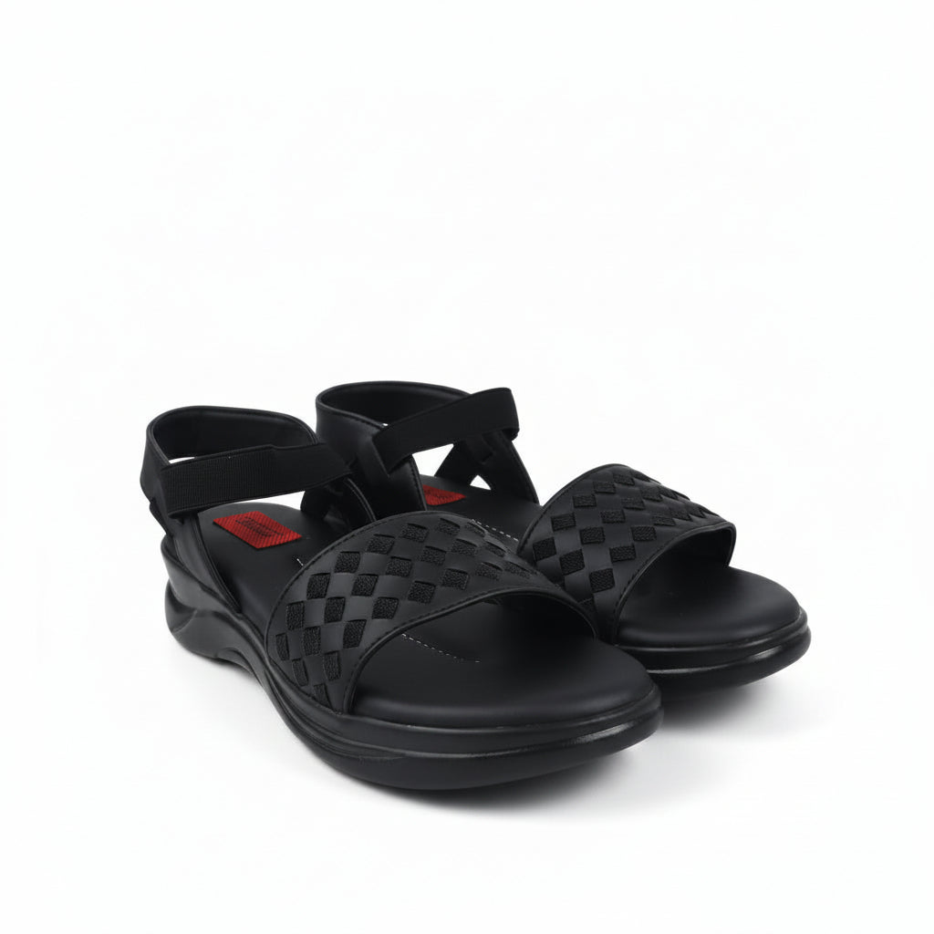 A pair of black woven-look slide sandals with adjustable ankle straps and bow details, photographed on a light gray studio background.