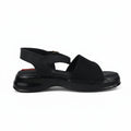 A single black platform sandal with a wide strap, textured upper, and slingback design, photographed against a light gray background.