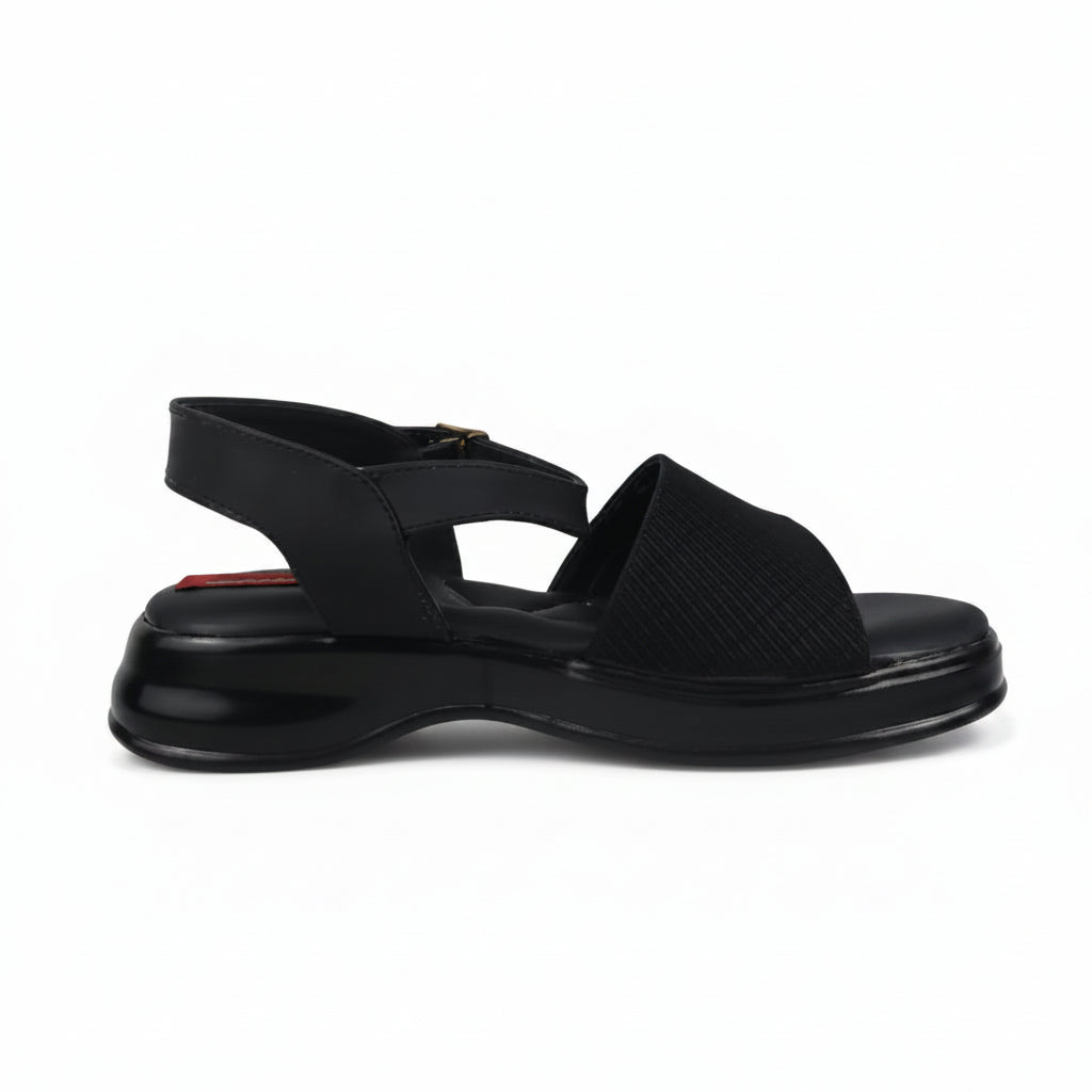A single black platform sandal with a wide strap, textured upper, and slingback design, photographed against a light gray background.