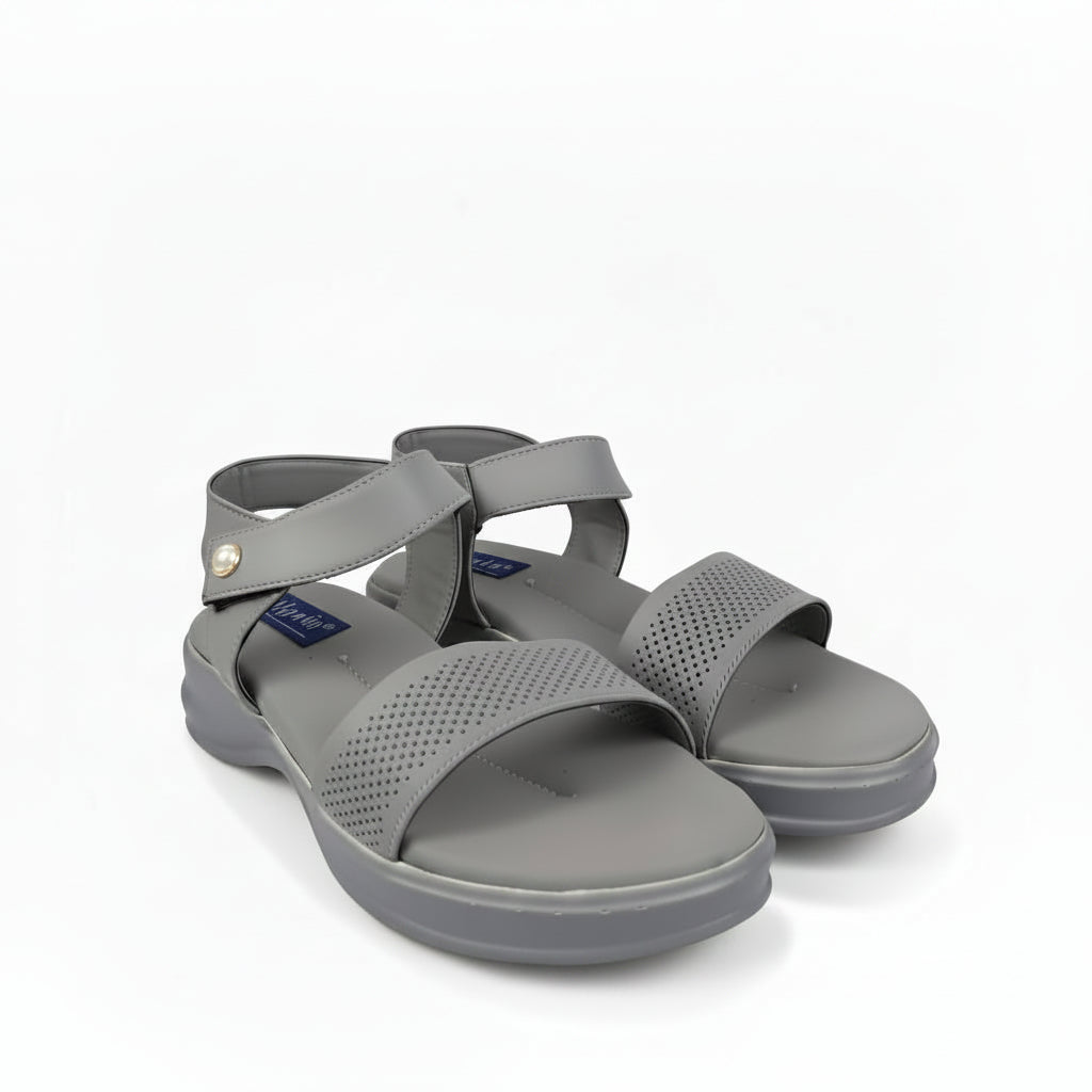 A pair of gray comfort sandals with perforated straps and adjustable ankle straps, shown on a light gray background.