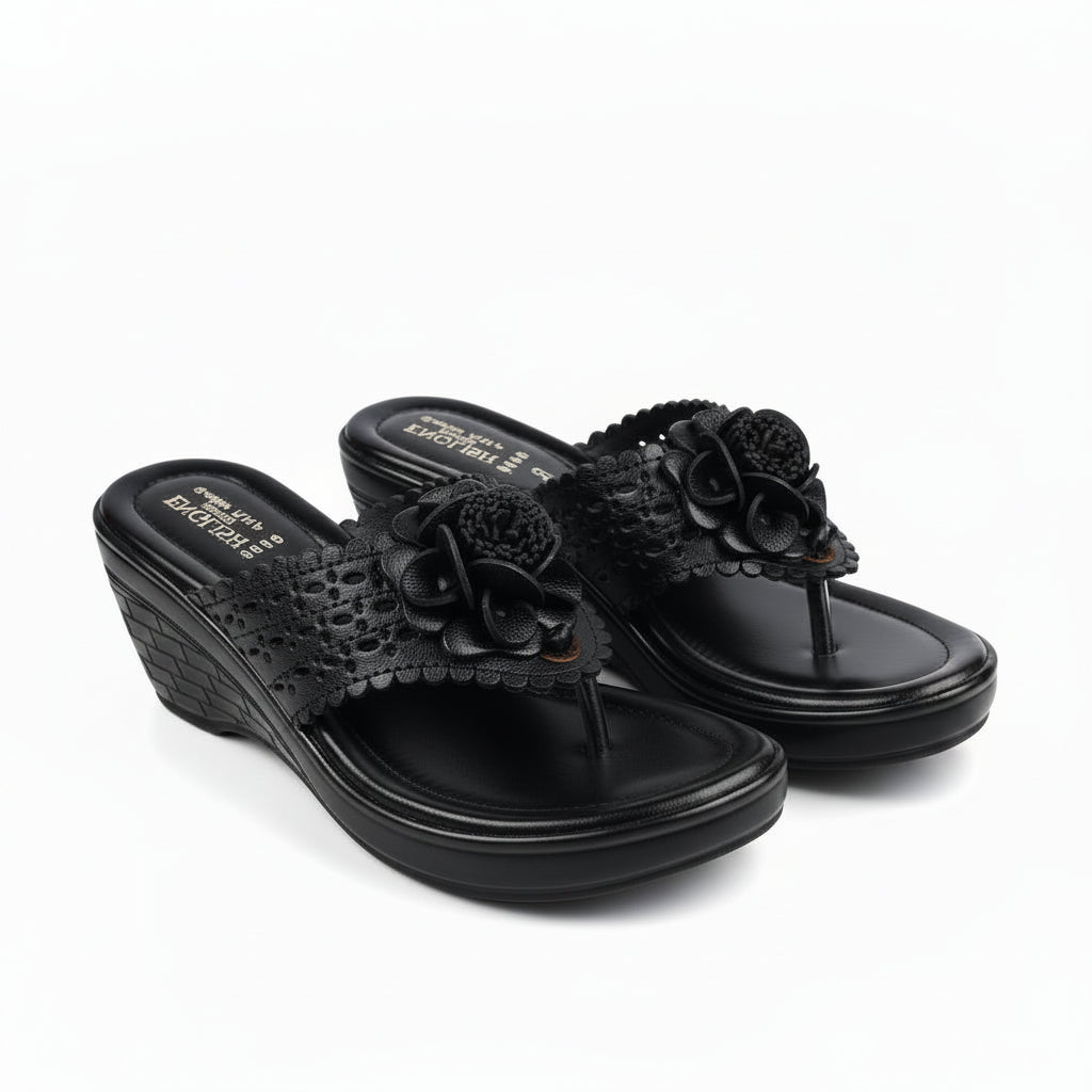 A pair of black wedge sandals with textured straps and 3D floral embellishments, shown on a plain white background.