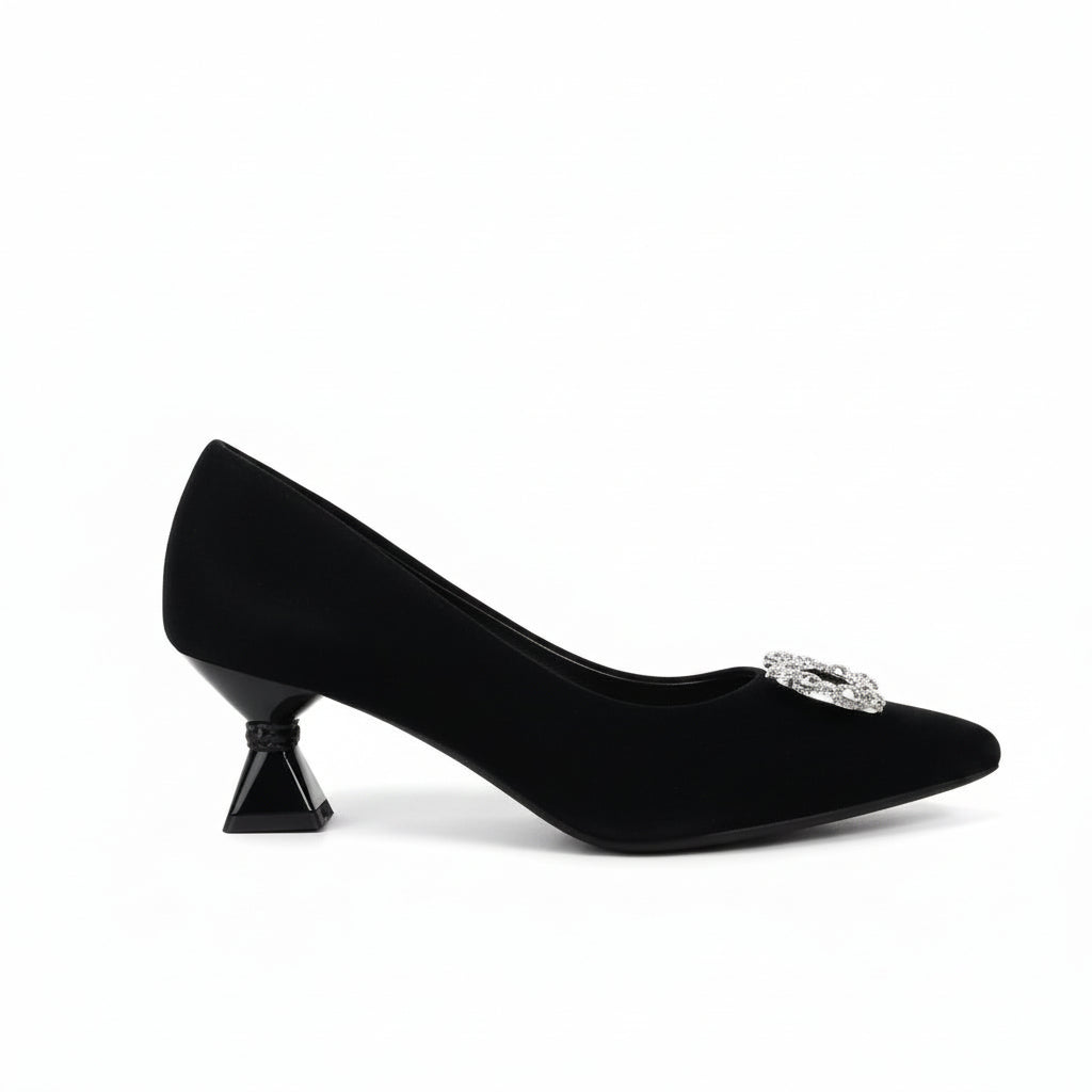 A pair of black pointed-toe kitten heels with large oval silver rhinestone embellishments on the front, photographed on a white studio floor.