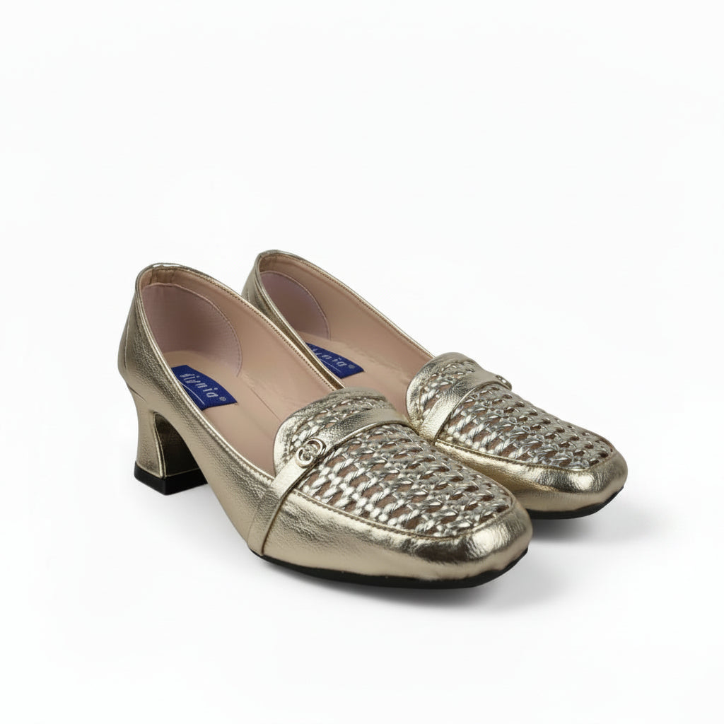 A pair of metallic gold women's loafers with a textured woven pattern across the toe, featuring a low block heel and black soles, set against a white studio backdrop.