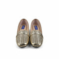A pair of gold metallic woven loafers with beige insoles, displayed on a white surface next to a shoebox.