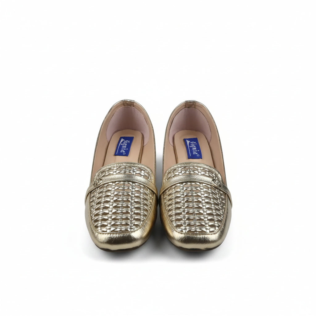 A pair of gold metallic woven loafers with beige insoles, displayed on a white surface next to a shoebox.