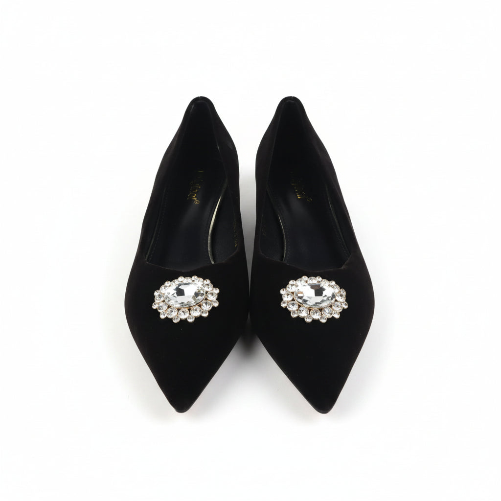 A pair of black pointed-toe high heels with ornate silver-tone and crystal embellishments on the toes, shown next to their orange and black shoebox on a white background.