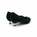 A pair of dark green velvet pointed-toe pumps with metallic gold heels and small silver rhinestone embellishments on the sides, photographed on a white studio background.