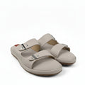 A pair of beige double-strap slide sandals with metal buckle closures, photographed on a white studio background.