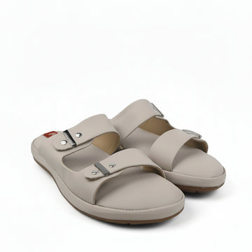 A pair of beige double-strap slide sandals with metal buckle closures, photographed on a white studio background.