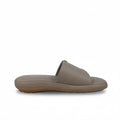 A single taupe leather slide sandal shown in profile against a white fabric backdrop.