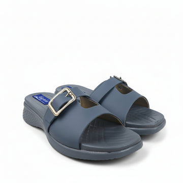 A pair of slate blue slide sandals with a single wide strap and a gold-tone buckle, shown on a white studio background.