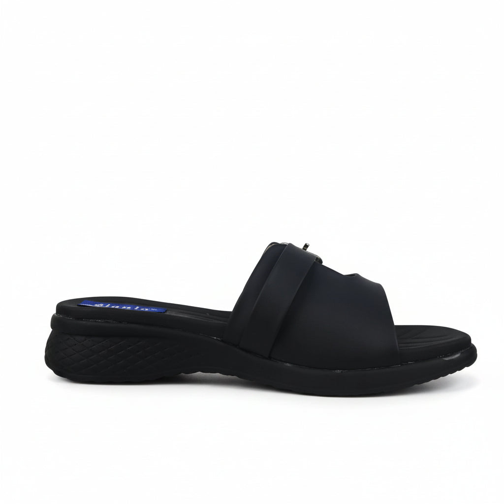 A single black slide sandal with a wide strap and a low wedge heel, shown from a side profile against a white studio background.