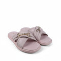 A pair of light pink slide sandals with double straps and gold-tone horsebit hardware, photographed on a white studio sweep with some visible creases and a black cable in the foreground.