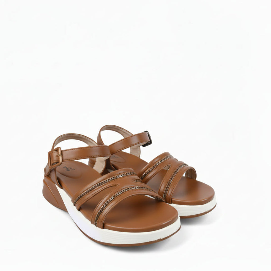 A pair of women's brown leather strappy sandals with rhinestone-embellished straps and white soles, photographed on a white fabric backdrop.