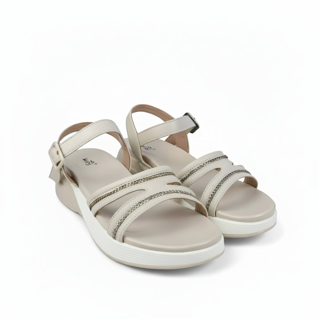 A pair of women's platform sandals in beige with metallic silver rhinestone-embellished straps, displayed on a white fabric backdrop.