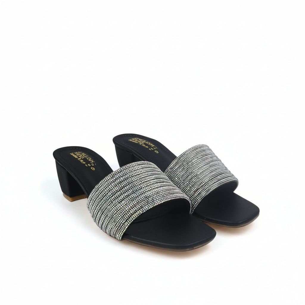 A pair of women's heeled slide sandals with wide, textured metallic silver and gold woven straps, black soles, and block heels, shown on a white studio backdrop.