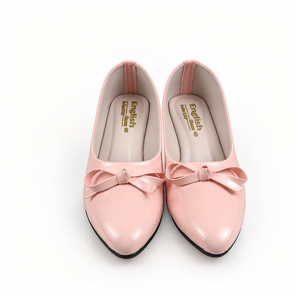A pair of light pink pointed-toe flats with matching fabric bows on the toes, displayed on a light gray surface.