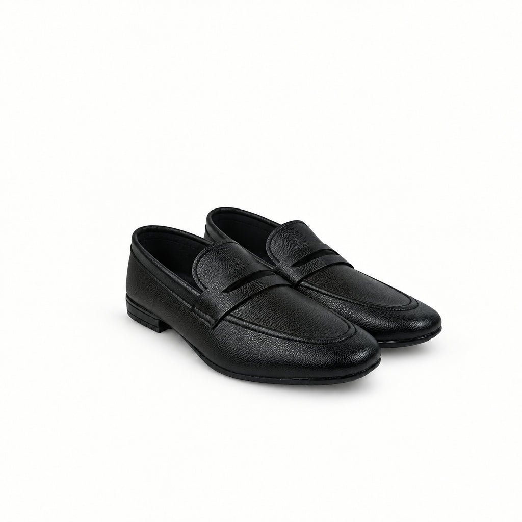 A pair of black leather penny loafers with a subtle pebbled texture, displayed on a light gray fabric backdrop.