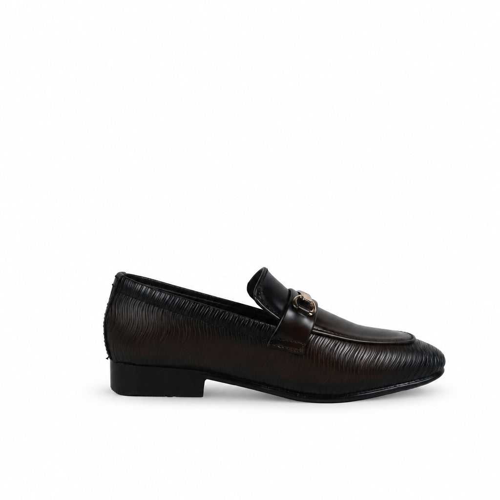 A single dark brown leather loafer with a textured pattern, low block heel, and a small gold-tone decorative accent on the strap, shown against a wrinkled white fabric background.