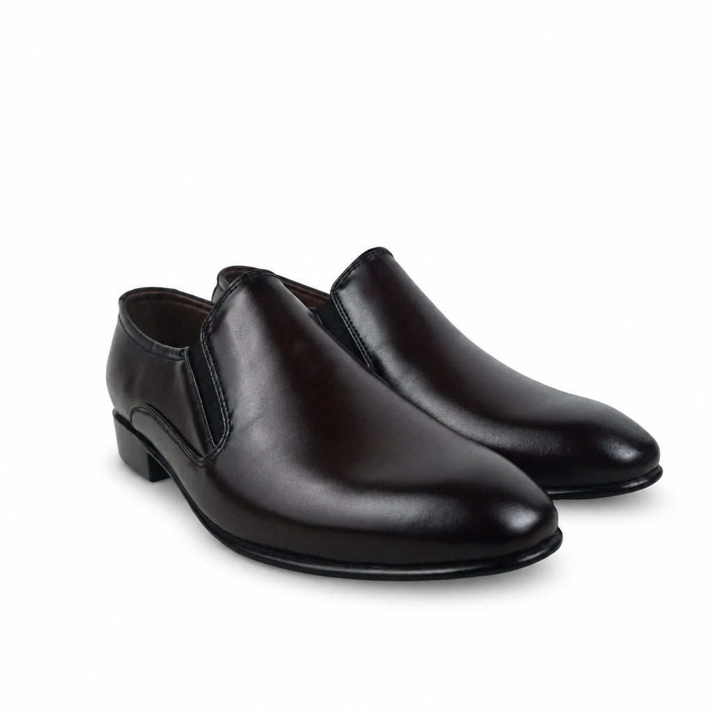 A pair of men's dark brown leather slip-on loafers with low block heels, displayed on a light gray surface with a crumpled white tissue in the background.