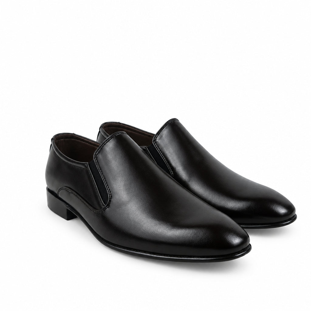 A pair of men's black leather slip-on dress shoes with elastic side panels, displayed on a white fabric backdrop.