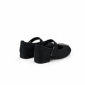A pair of black flat shoes with decorative silver embellishments on the toe, photographed on a white fabric backdrop.