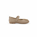 A single beige flat shoe with a decorative gold embellishment on the toe, shown in profile against a light gray fabric backdrop.