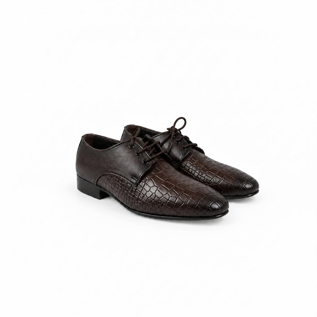 A pair of dark brown leather lace-up dress shoes with an embossed crocodile pattern, displayed on a white fabric backdrop.