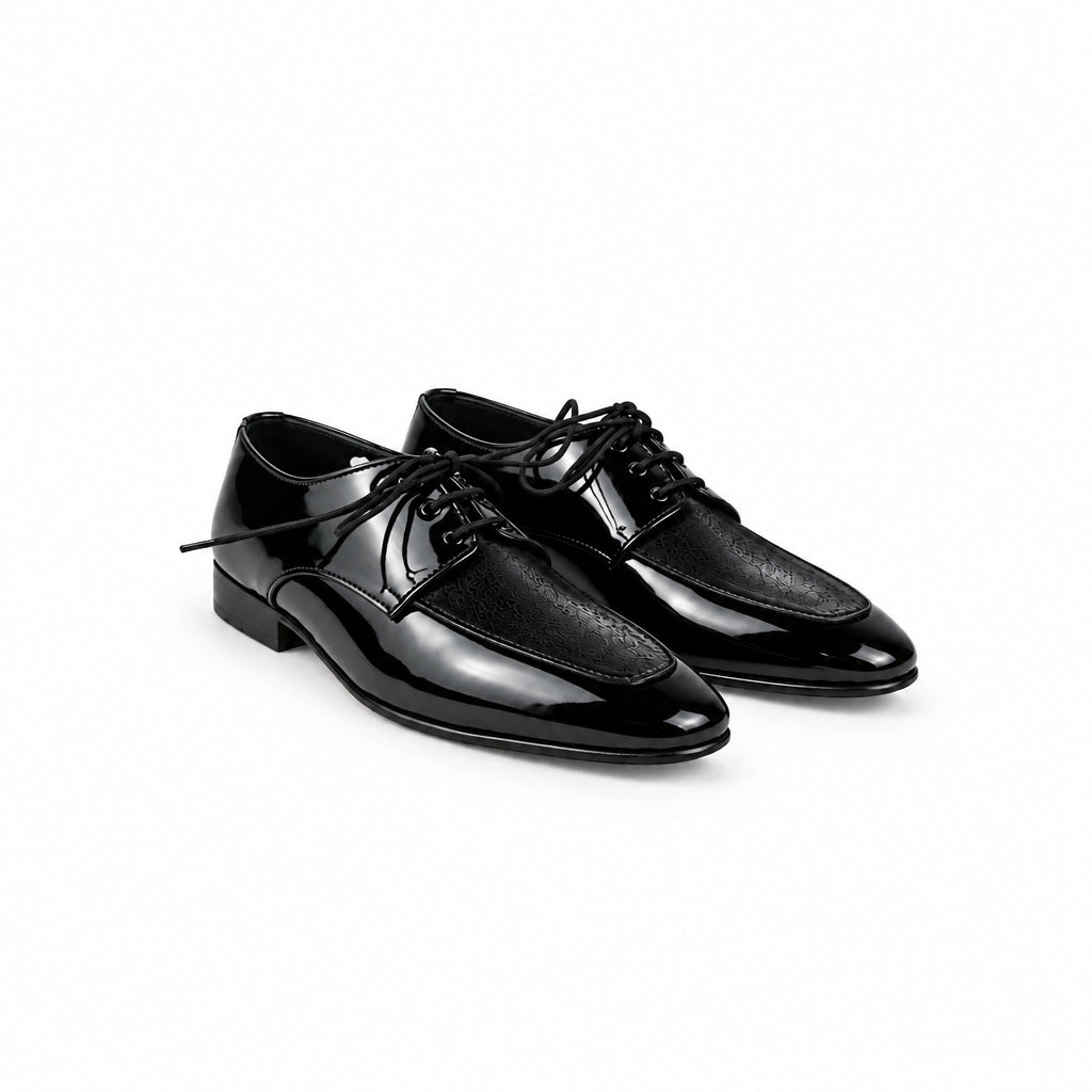 A pair of shiny black patent leather oxford shoes with black laces, displayed on a light gray fabric background.