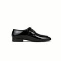 Black slip-on shoe with white sole on a light gray background