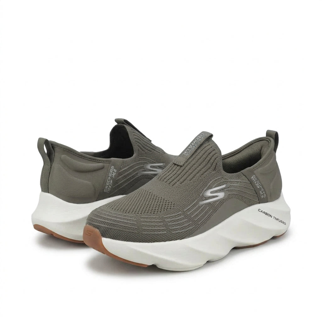 A pair of Skechers slip-on sneakers in a muted gray color, featuring a textured knit upper, a white sculpted midsole, and a brown outsole, shown against a plain light gray background.