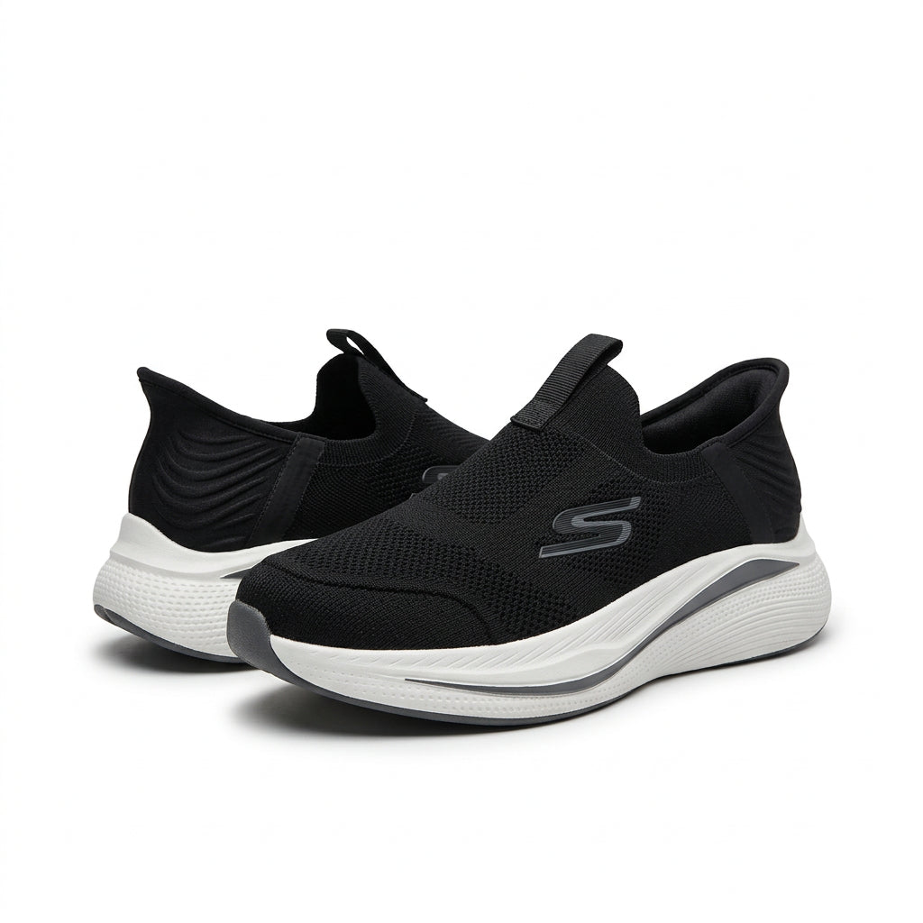A pair of Skechers slip-on sneakers in black with a white and black sole, shown against a plain white background.
