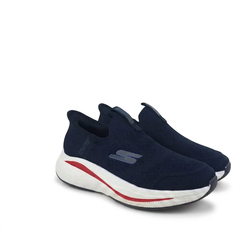 A pair of Skechers slip-on sneakers in navy blue, featuring a white midsole with a red accent line and a gray logo on the side, set against a plain white background.