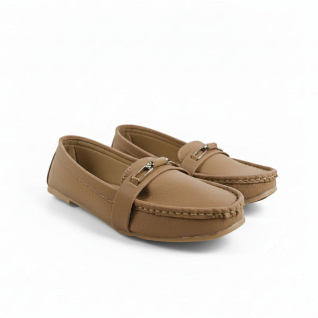 A pair of tan faux-leather moccasin loafers with a small silver buckle detail on the strap, shown on a plain white background.