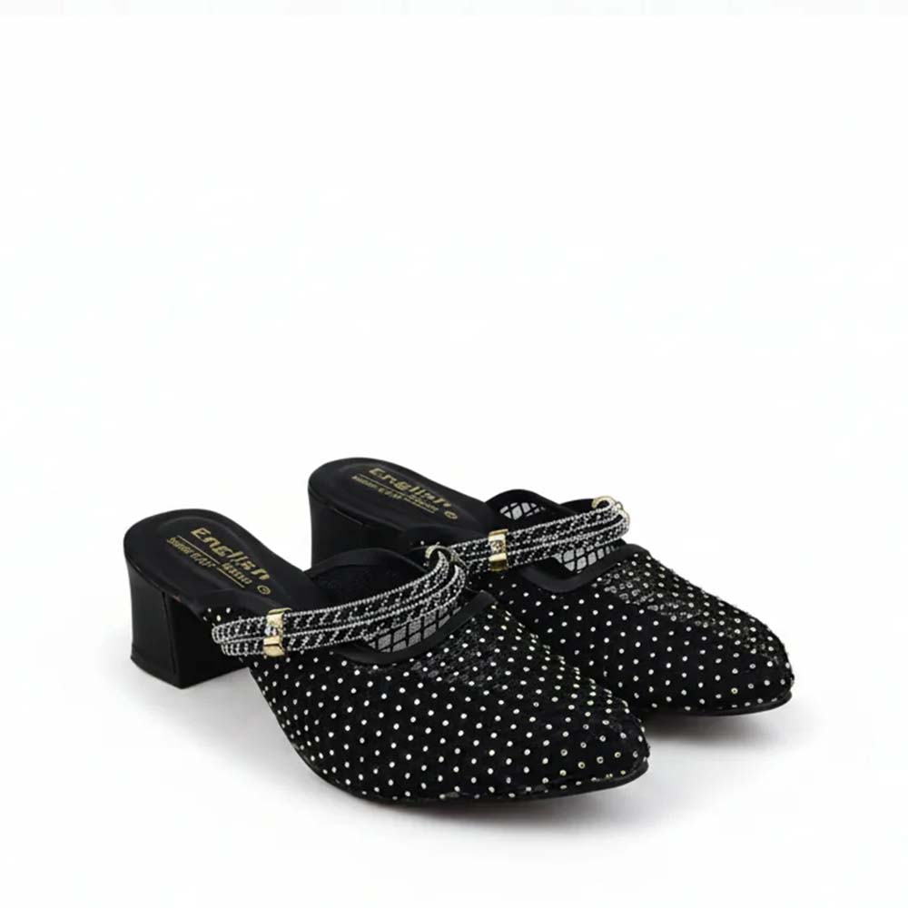 A pair of black mule heels covered in silver rhinestones, featuring a pointed toe, a low block heel, and a rhinestone-embellished strap with gold-tone hardware.