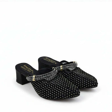 A pair of black mule heels covered in silver rhinestones, featuring a pointed toe, a low block heel, and a rhinestone-embellished strap with gold-tone hardware.