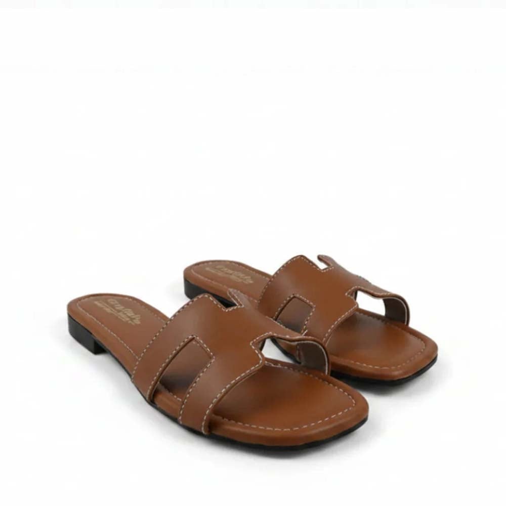 A pair of brown leather slide sandals with cutout straps, shown on a plain white background.