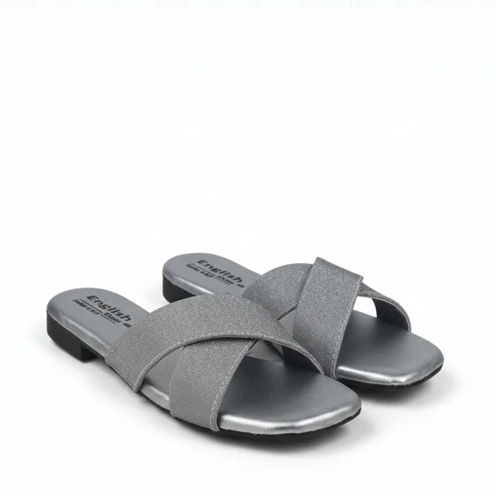 A pair of women's slide sandals in a metallic silver color, featuring criss-crossing straps and a low block heel, shown on a plain white background.