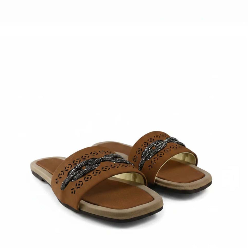 A pair of women's slide sandals in tan leather with laser-cut geometric patterns and a woven black-and-gold braided strap, shown on a white background.