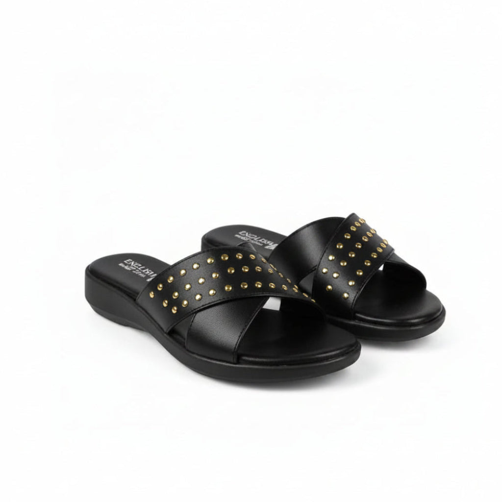 A pair of black slide sandals with gold-tone metal studs arranged in a crisscross pattern across the straps, shown on a plain white background.