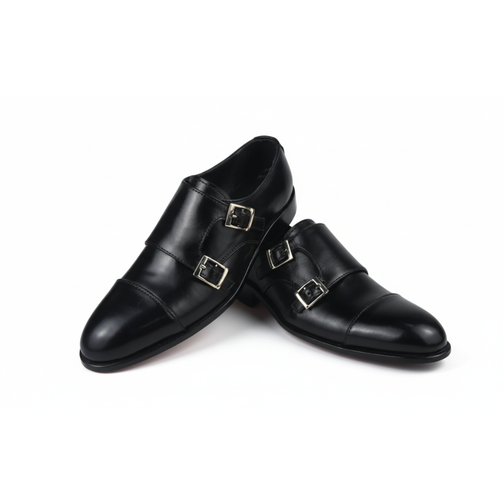 Black leather shoes with gold buckles on a white background